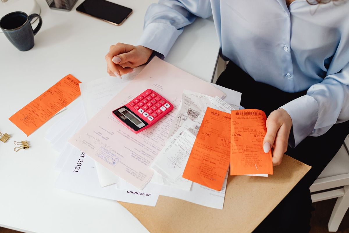 Debt Settlement Programs — person with receipts and a calculator