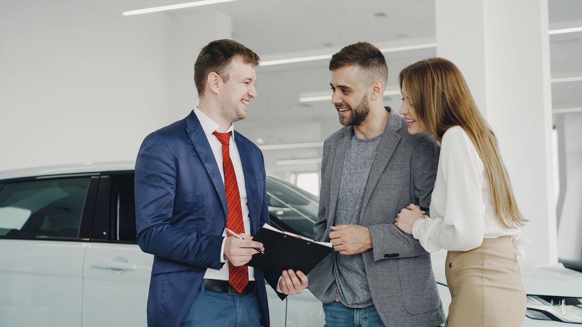 Debt consolidation loans in Charleston, WV — couple meeting a finance manager about a vehicle purchase