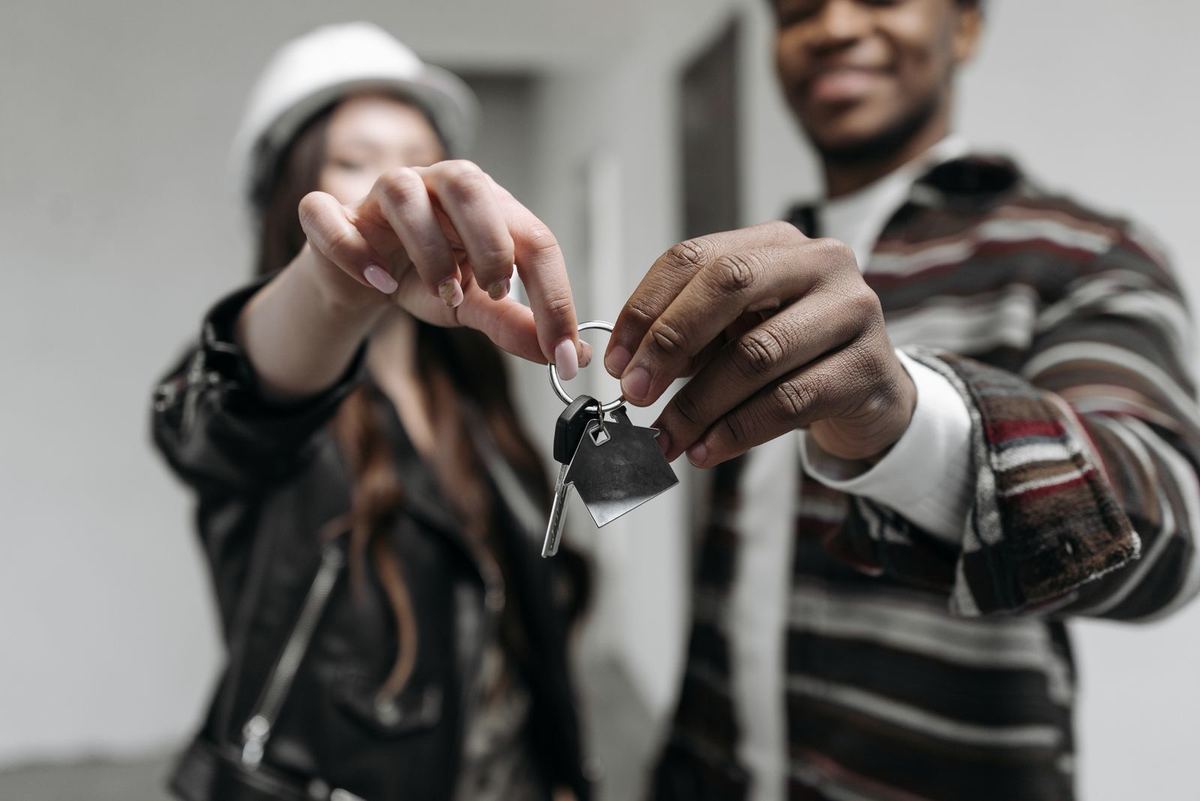 Debt consolidation loans in Parkersburg, WV — couple holding up the keys to their first home