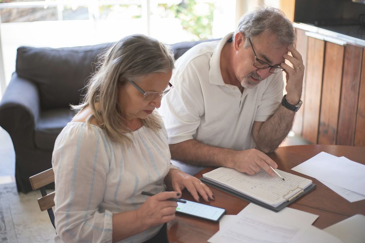Payday Loan Relief in Charleston, WV — older couple planning payments on a phone and notepad