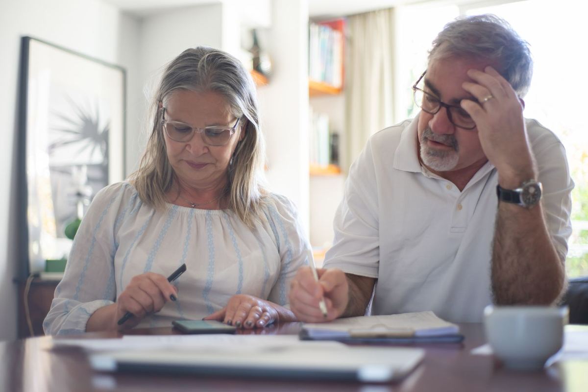 Debt Negotiation Services — couple calculating household expenses