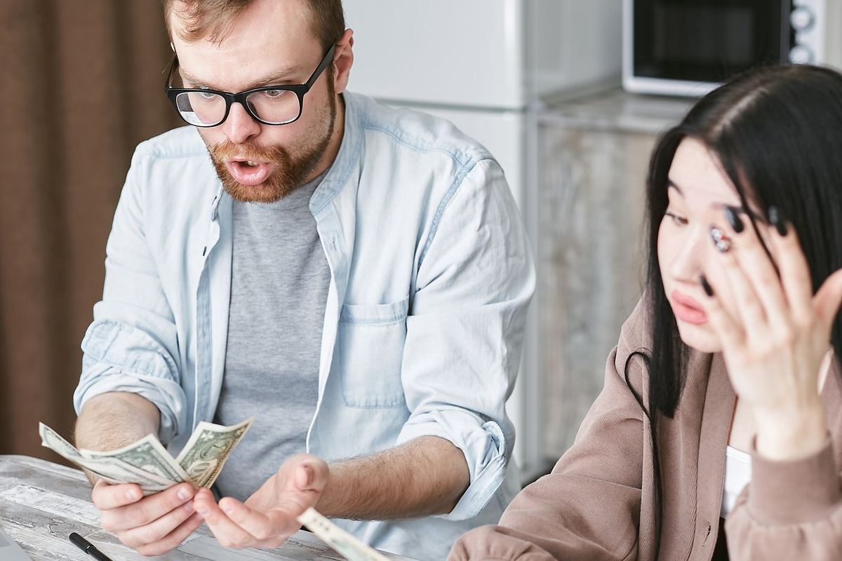 Payday Loan Consolidation in Charleston, WV — couple facing a stack of bills