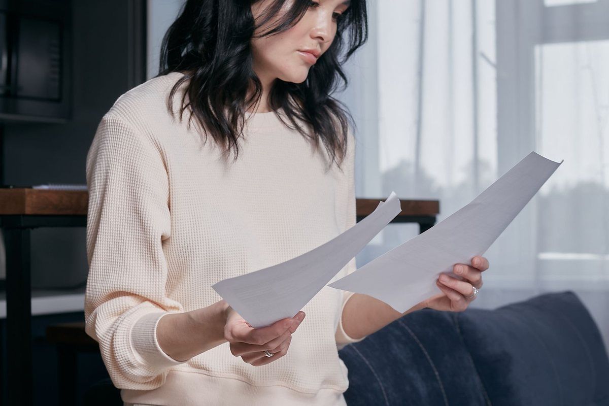 Credit card debt relief in West Virginia — woman reading documents at home