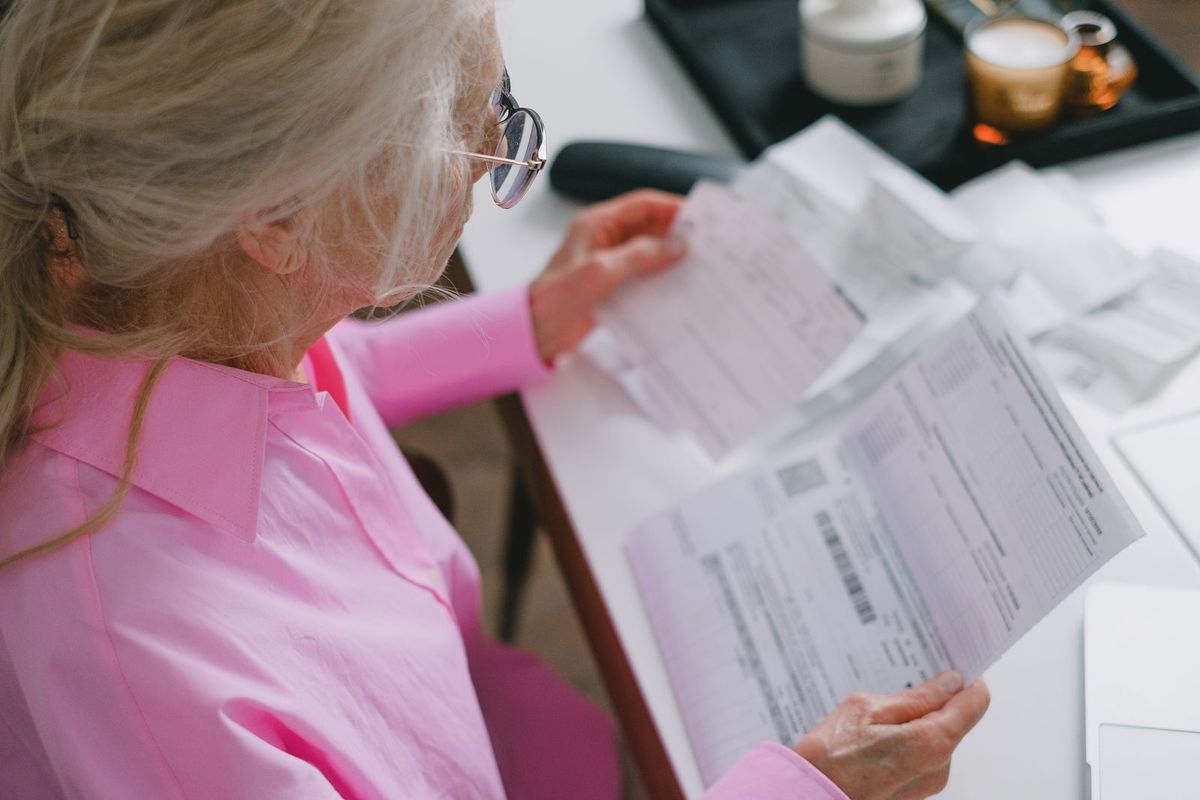 Debt Consolidation Programs — older woman reading a document