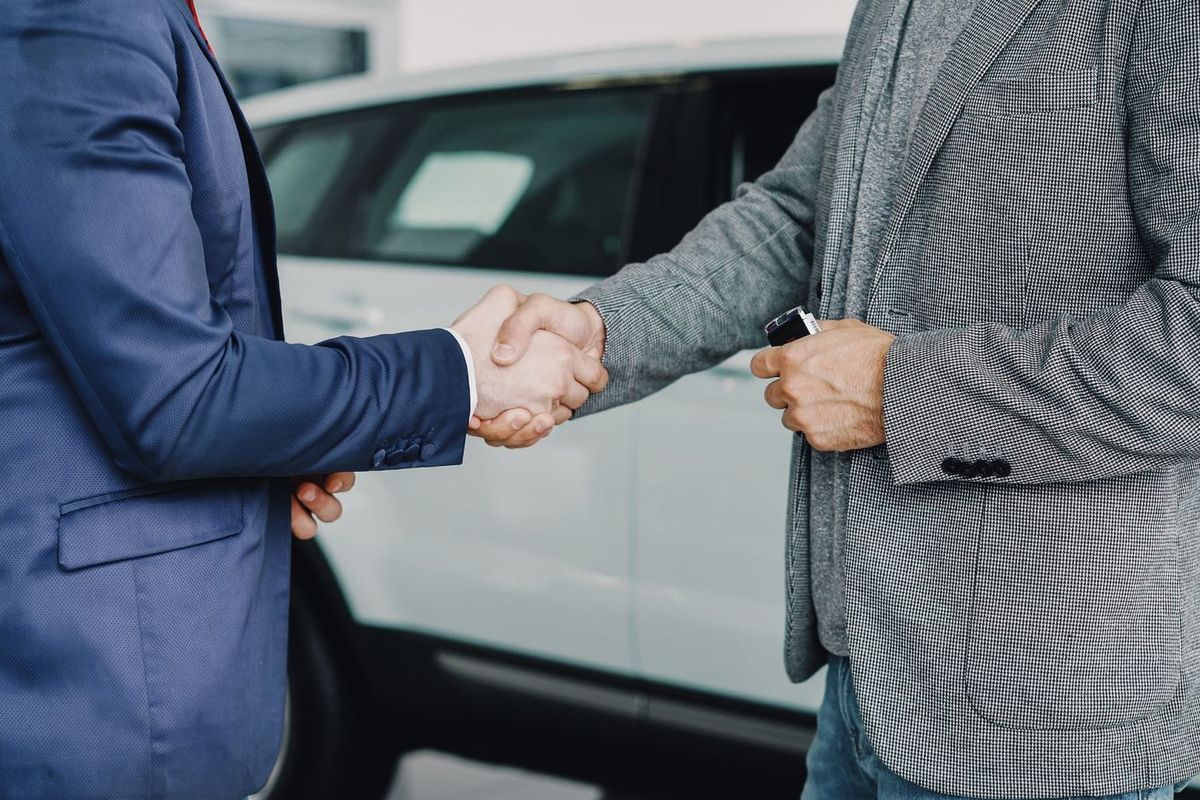 Debt consolidation loans in Wheeling, WV — handshake at a car dealership