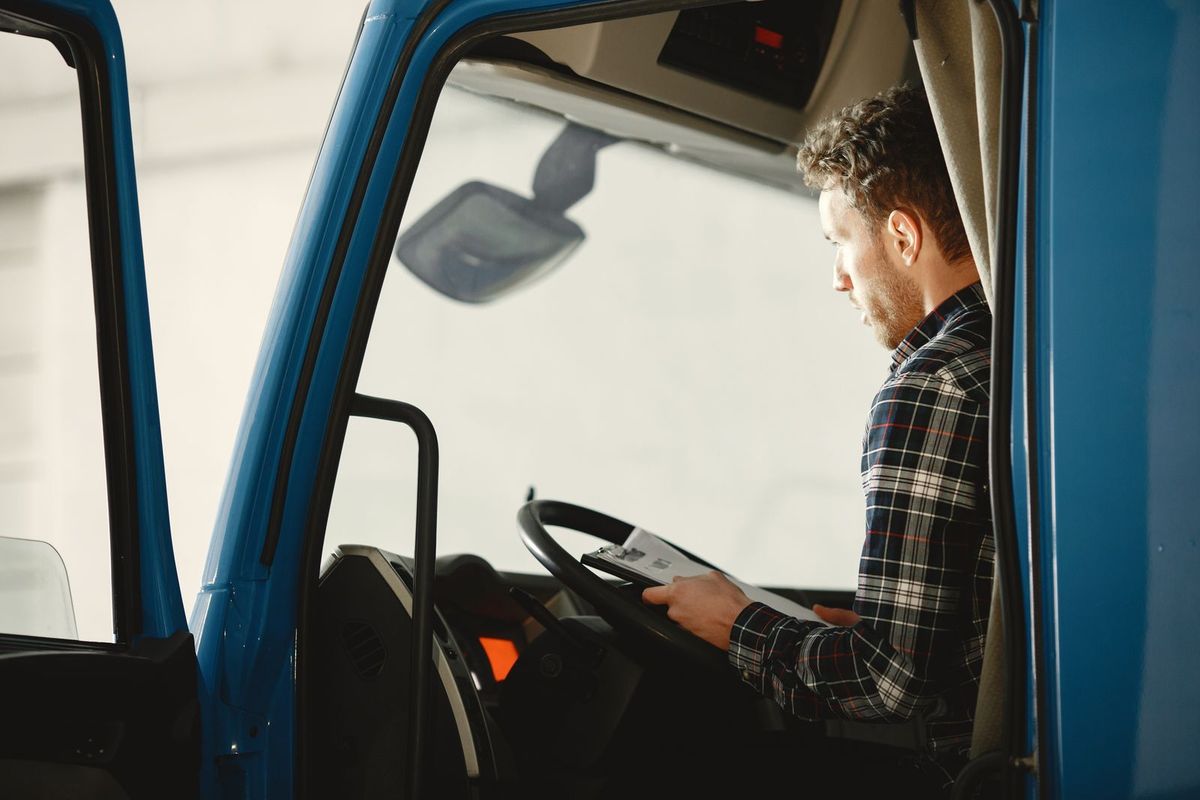 Payday Loan Consolidation in Charleston, WV — driver reviewing paperwork in his truck cab