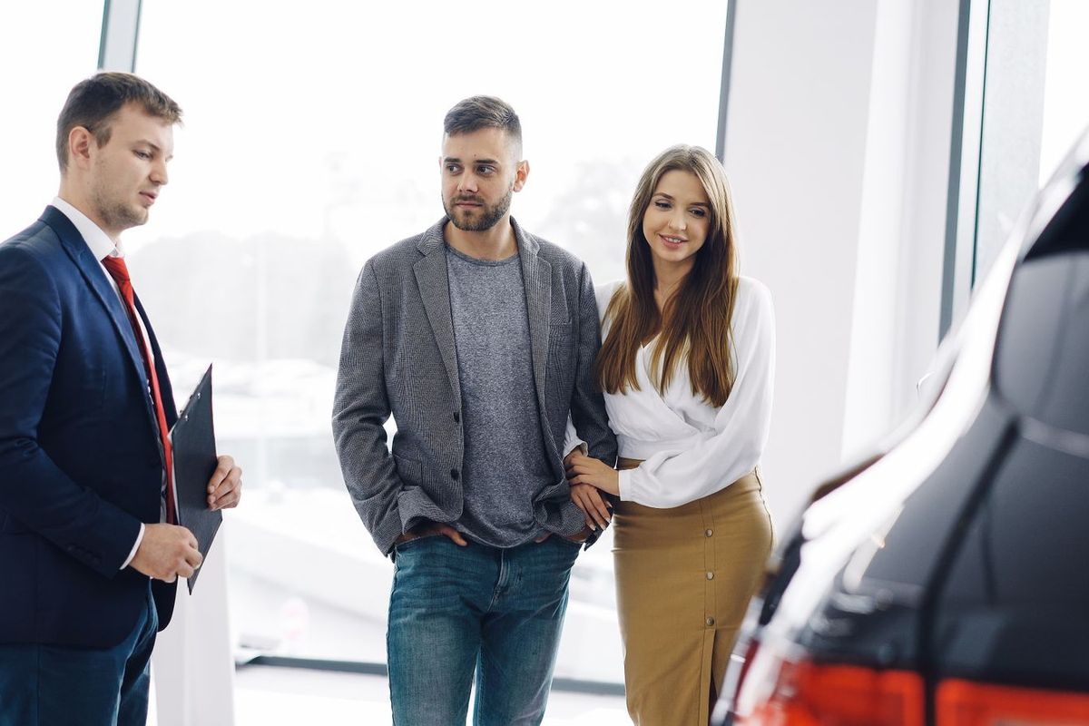 Debt Consolidation Programs — young couple at a car dealership