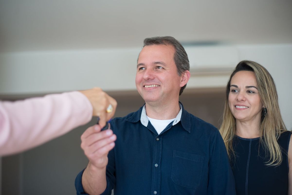 Debt consolidation loans in Huntington, WV — couple receiving keys from a broker